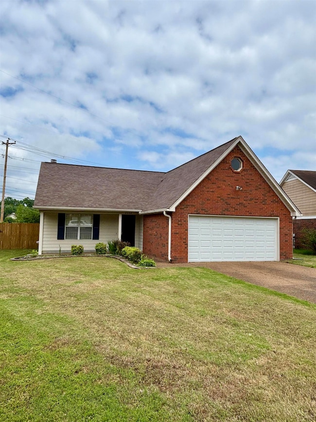 View of front facade with driveway, a garage, and brick siding