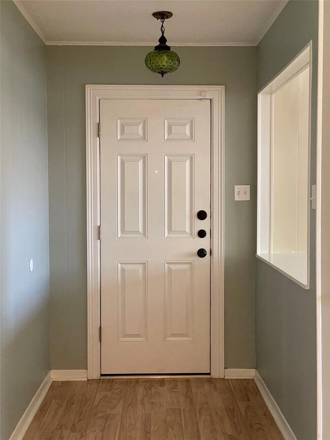 Entryway featuring crown molding, baseboards, and