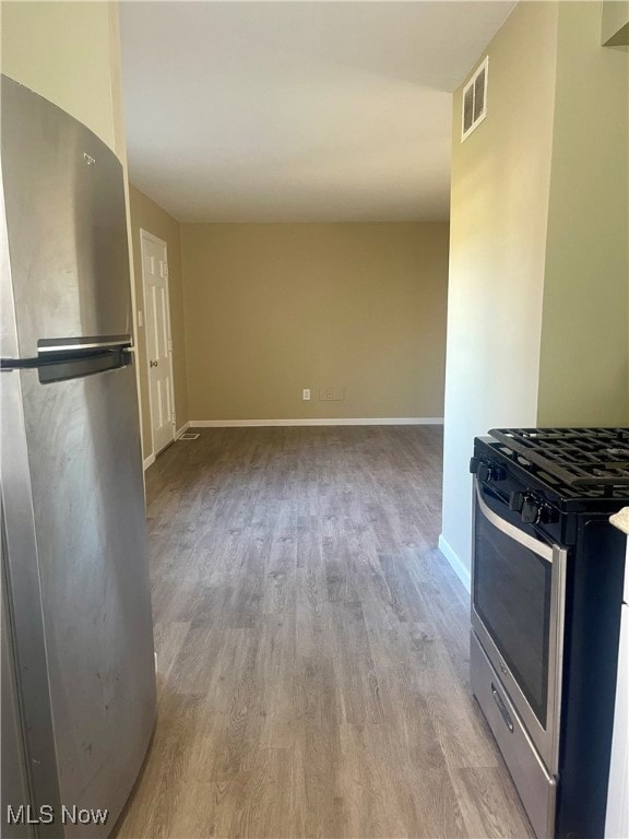 Kitchen featuring appliances with stainless steel finishes and light wood-style flooring