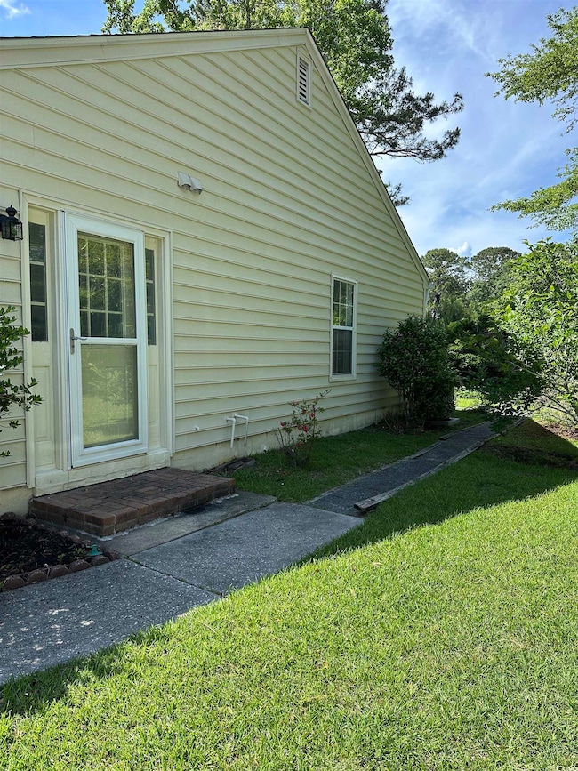 View of property exterior with a lawn