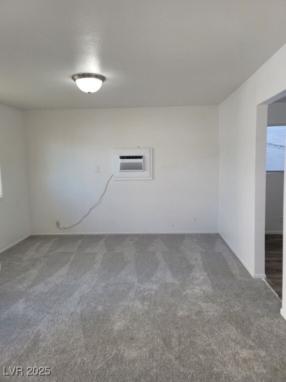 Unfurnished room with carpet flooring, a wall moun