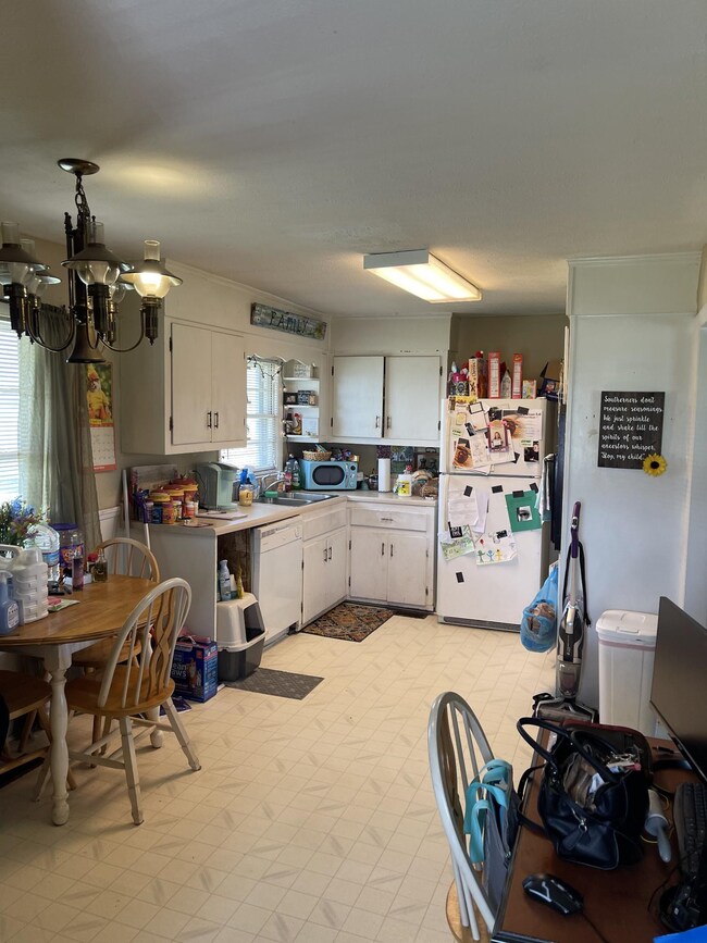 View from side entrance of home where you enter the kitchen / dining room.  The laundry is located in this room behind bifold doors. 