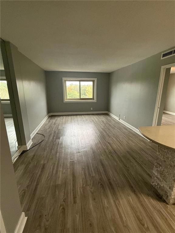 Unfurnished room featuring dark wood-type flooring and baseboards