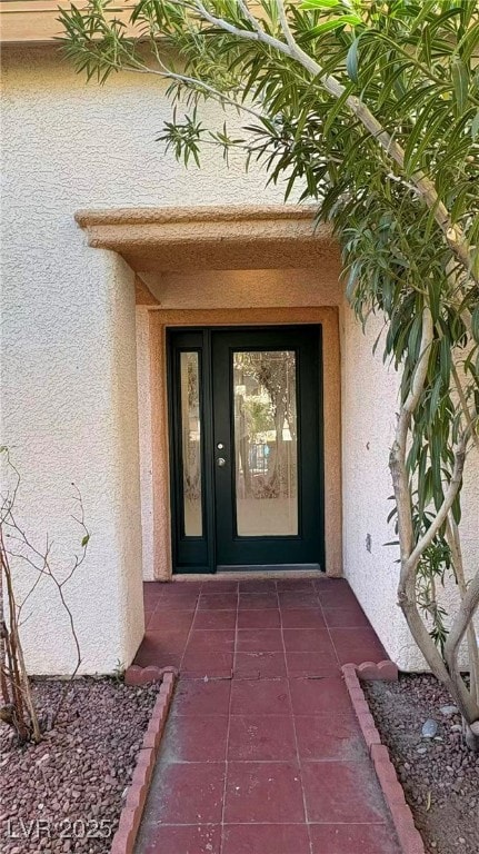 View of exterior entry featuring stucco siding