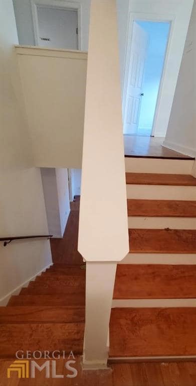 Stairway featuring wood finished floors