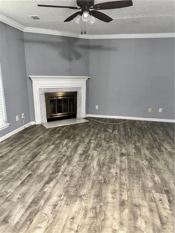 Unfurnished living room featuring a fireplace, wood finished floors, a ceiling fan, and ornamental molding