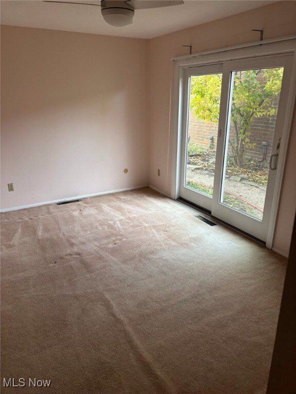 Spare room featuring carpet and baseboards