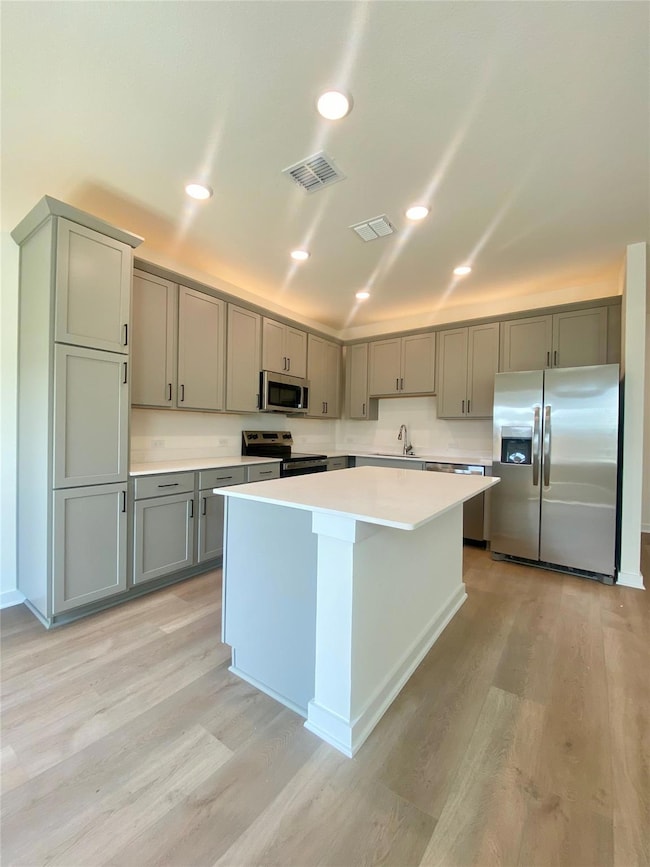 Kitchen with stainless steel appliances, gray cab