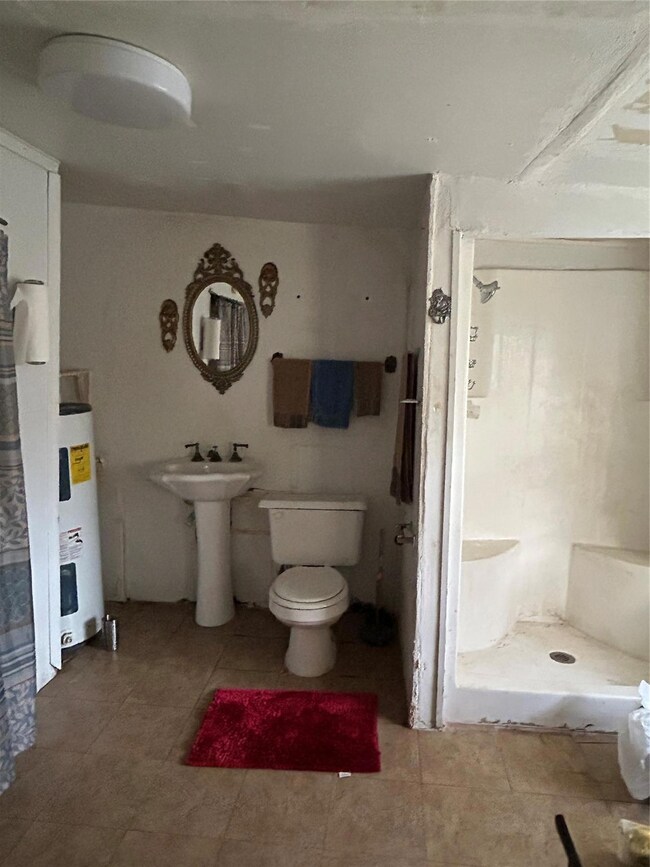 Full bath featuring toilet, a stall shower, water 