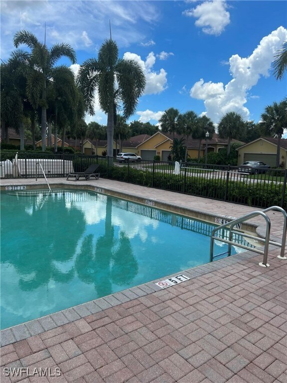 Pool with a patio area and fence