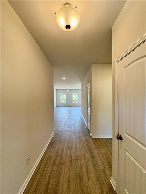 Corridor with wood finished floors and baseboards