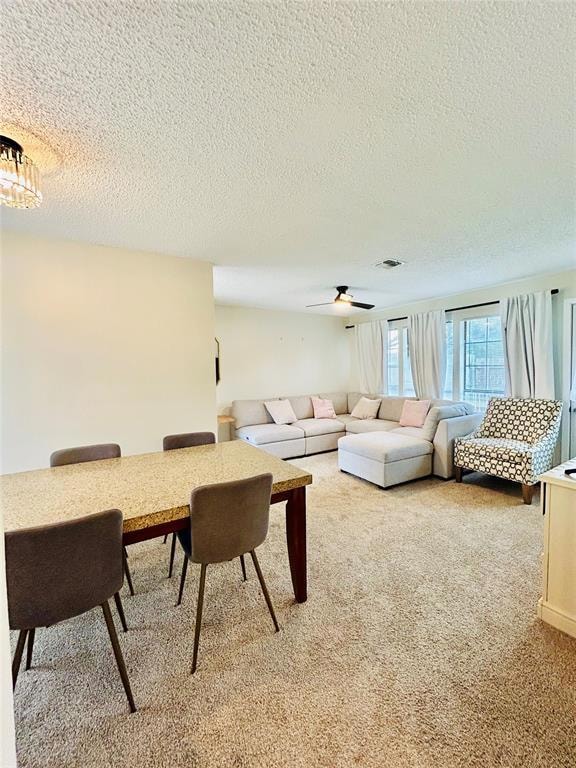 Living area with light colored carpet, and a ceiling fan