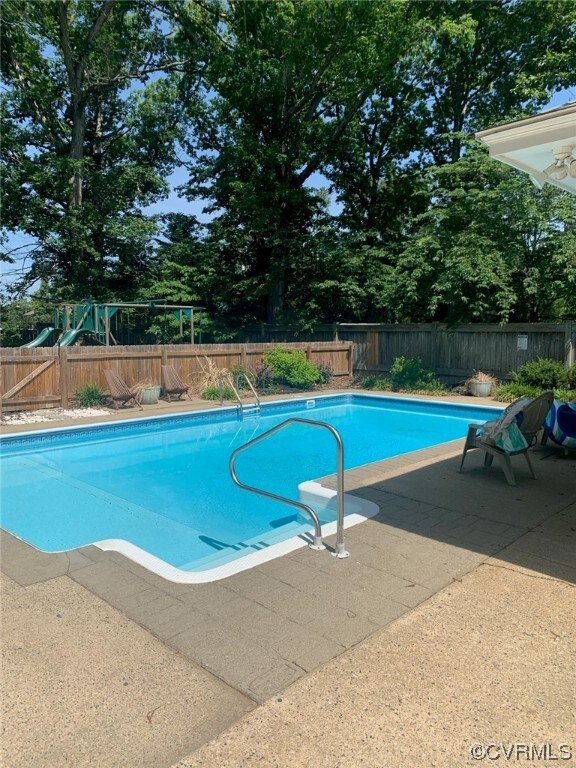View of swimming pool featuring a playground and a