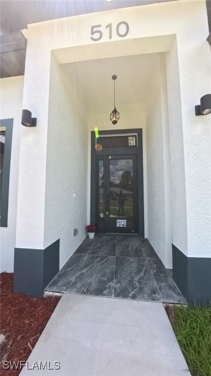 Doorway to property featuring stucco siding