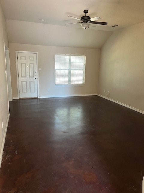 Empty room featuring vaulted ceiling, a ceiling fan, and concrete flooring