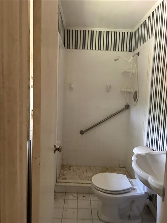 Full bathroom featuring a shower stall and toilet