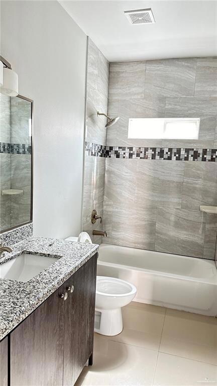 Full bath featuring vanity, washtub / shower combination, and tile patterned floors