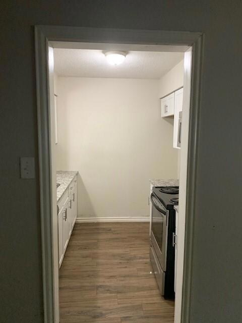 Kitchen with white cabinets, wood finished floors,