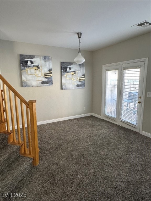 Carpeted spare room with baseboards and stairway