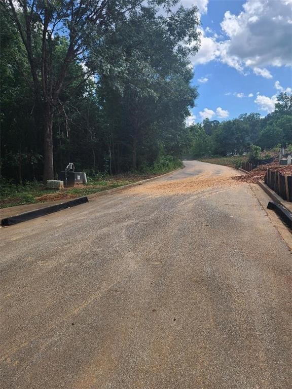 View of asphalt street featuring curbs
