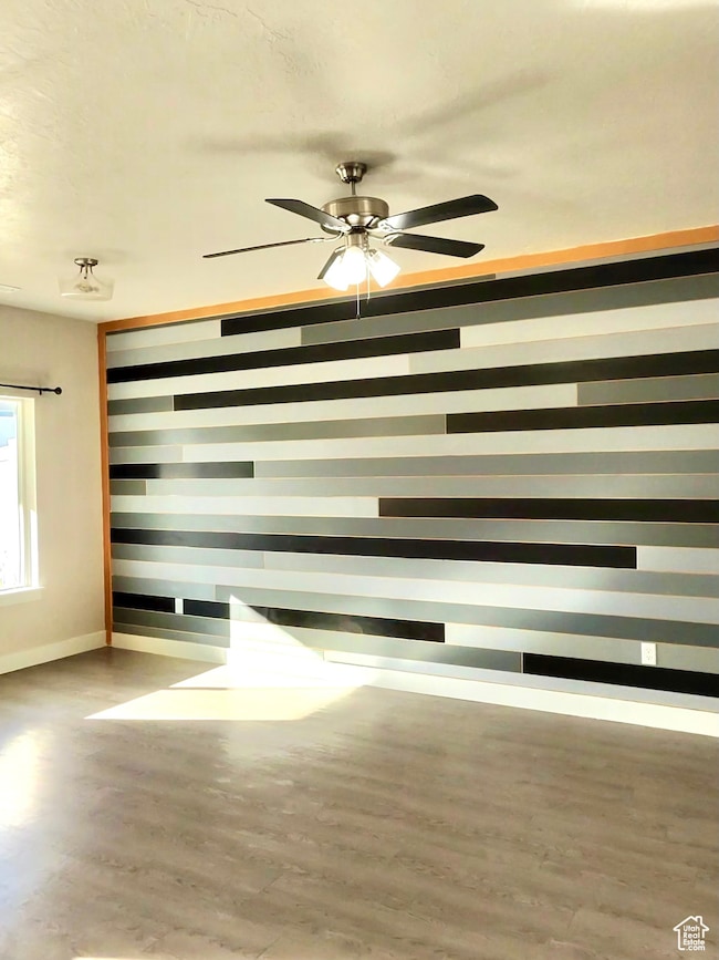 Spare room featuring light wood-style flooring and a ceiling fan