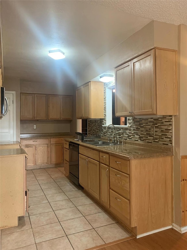 Kitchen with tasteful backsplash, dishwasher, light brown cabinets, and light tile patterned floors