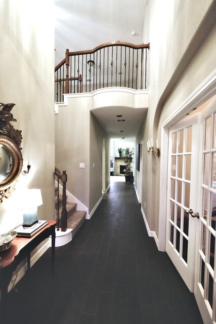 Upon entering the residence, one is welcomed into a soaring entry hall leading to the principal living area at rear of image. French doors at right of image afford privacy for a multi-purpose bonus room that can be utilized as an office, studio, nursery, kids' playroom or project room.