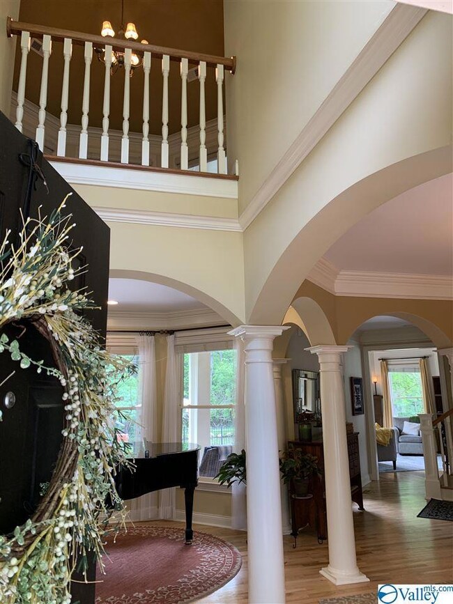 This home boasts a welcoming two-story foyer, flanked by formal dining and living rooms, and leads to a sun-drenched octagonal conservatory, overlooking the expansive landscaped patio and lake.