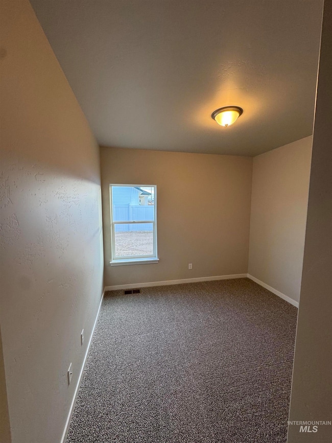 Carpeted empty room with baseboards