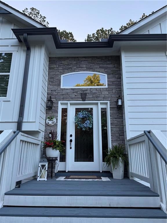 Entrance to property with stone siding and board and batten siding