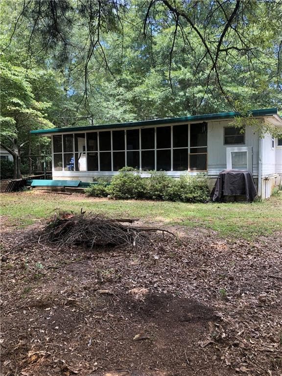 Rear view of house featuring a sunroom