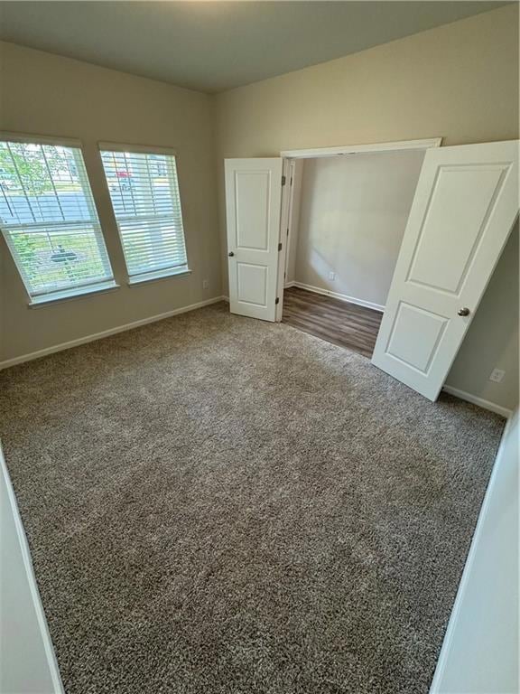 Unfurnished bedroom featuring baseboards and carpet flooring
