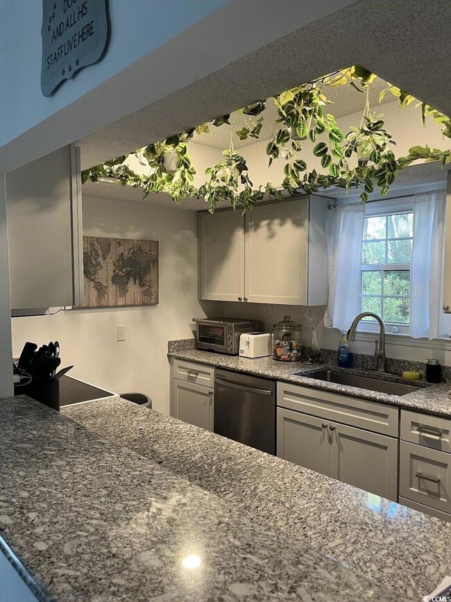 Kitchen with stainless steel dishwasher, gray cabi
