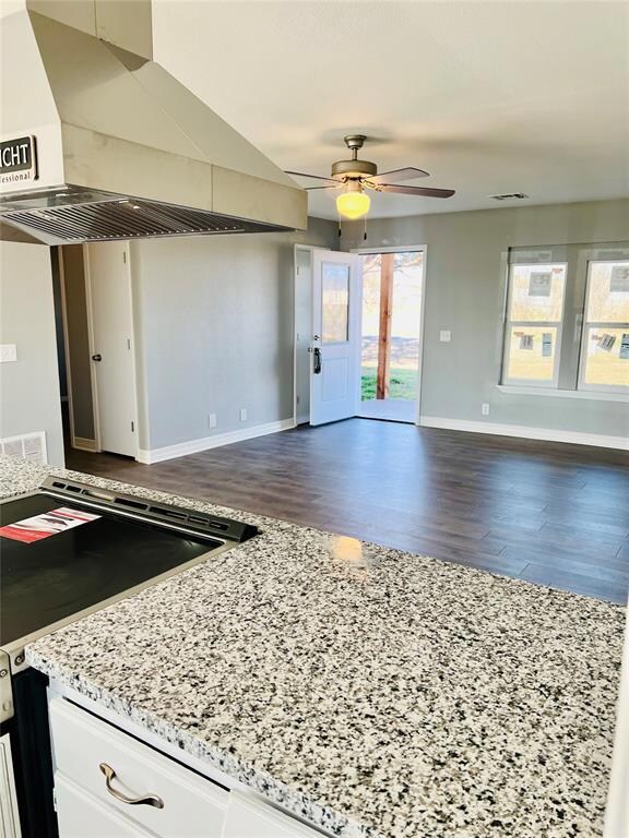 Kitchen with white cabinets, ceiling fan, dark har