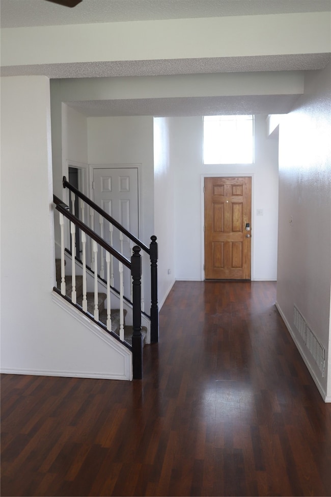 Foyer entrance featuring stairway and dark wood-style floors