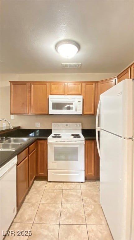 Kitchen with white appliances, dark countertops, l