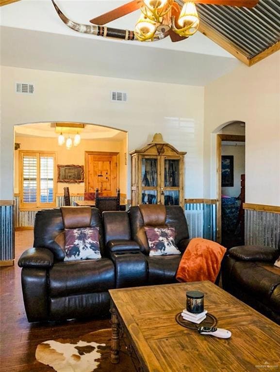 Living room with a chandelier, arched walkways, and wood finished floors