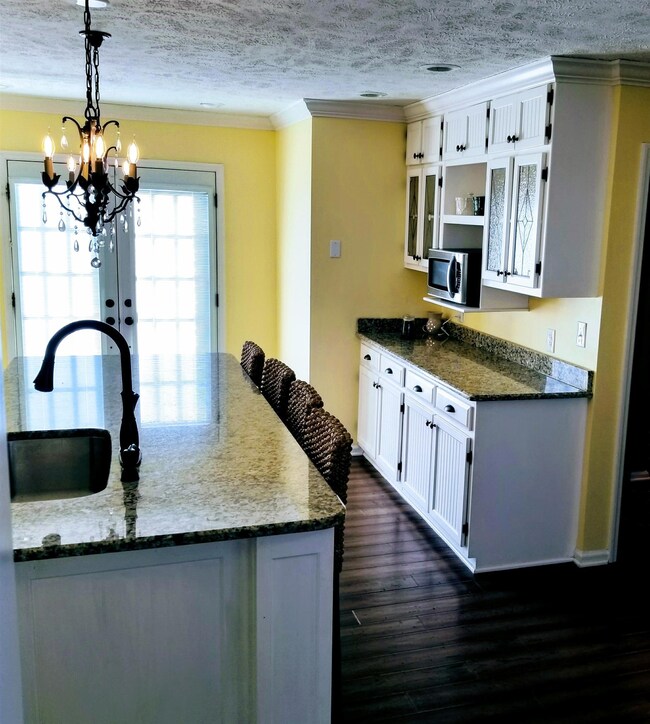 This view of the kitchen shows the french doors leading to the outside & backyard entrance.