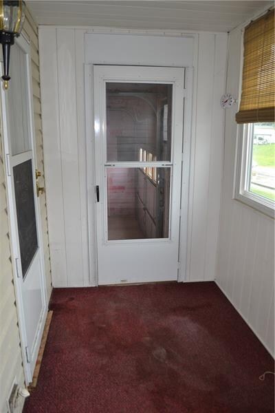 Enclosed front porch leading to garage and home.