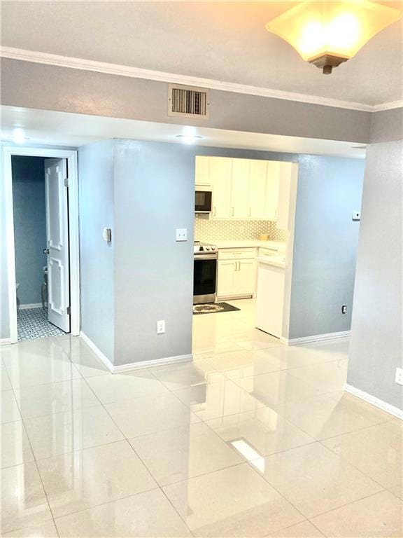 Spare room featuring light tile patterned flooring and crown molding