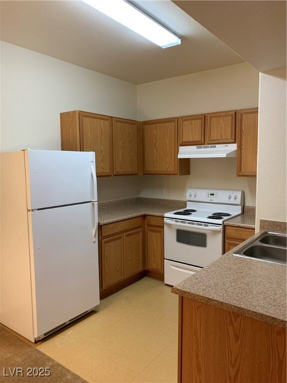 Kitchen with refrigerator, stove, extractor fan, a