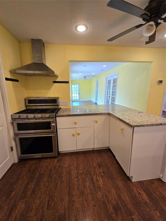 Kitchen with ceiling fan, dark hardwood / wood-sty