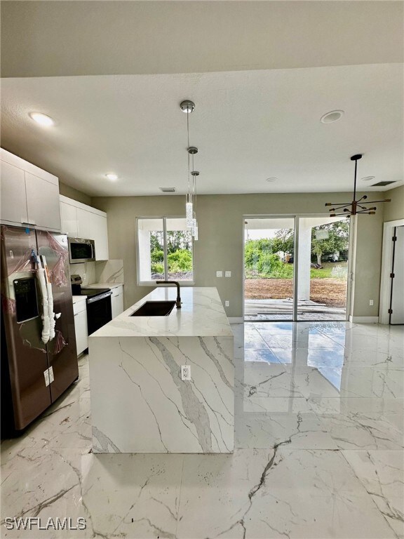 Kitchen with pendant lighting, sink, white cabinet
