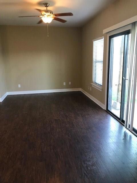 Spare room featuring dark wood-style floors and ceiling fan