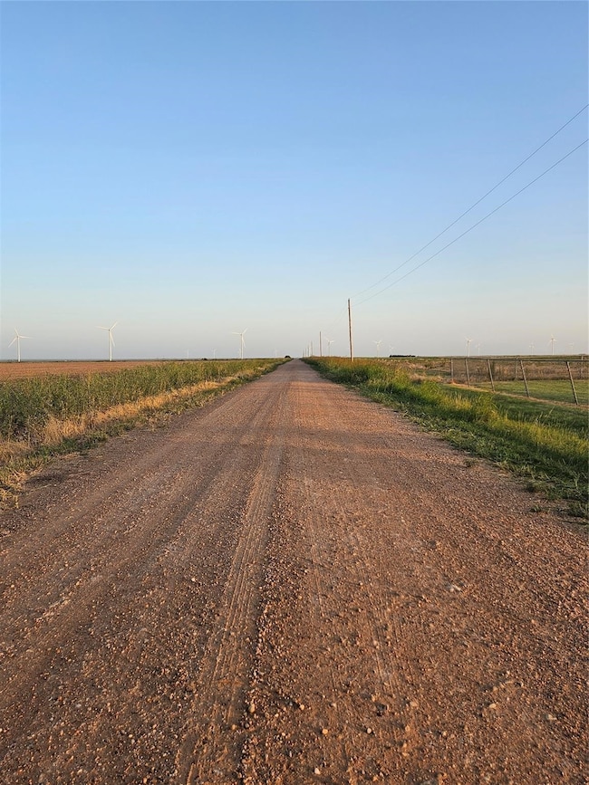 View of dirt / gravel road with a view of rural / pastoral area