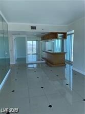 Unfurnished living room with ornamental molding and tile patterned flooring