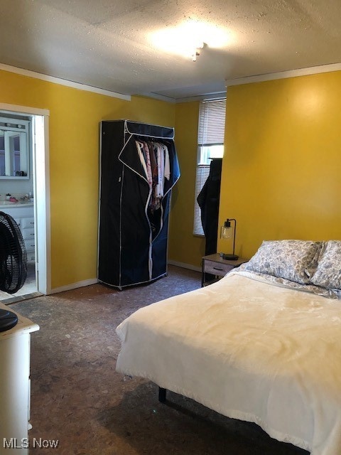 Bedroom with ornamental molding and a textured ceiling