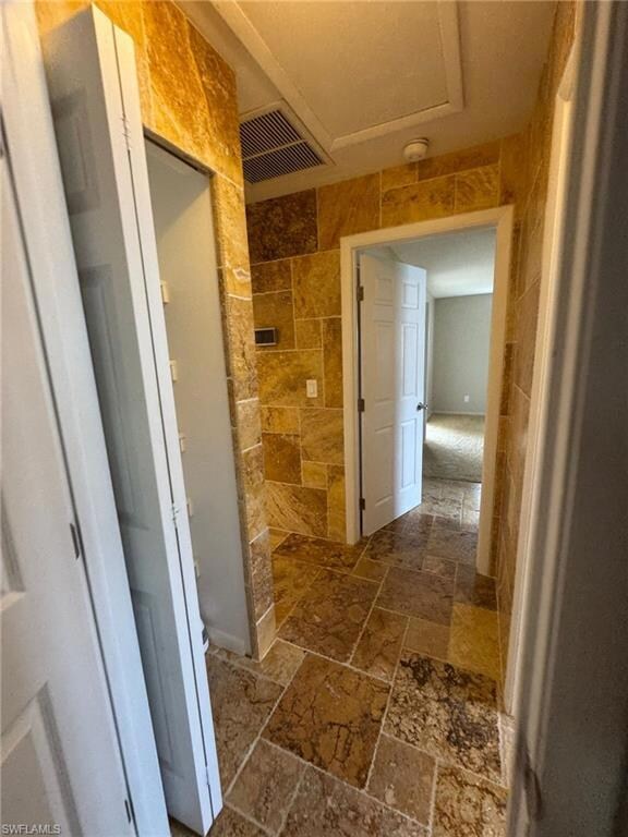 Bathroom featuring tile walls, stone tile floors, 
