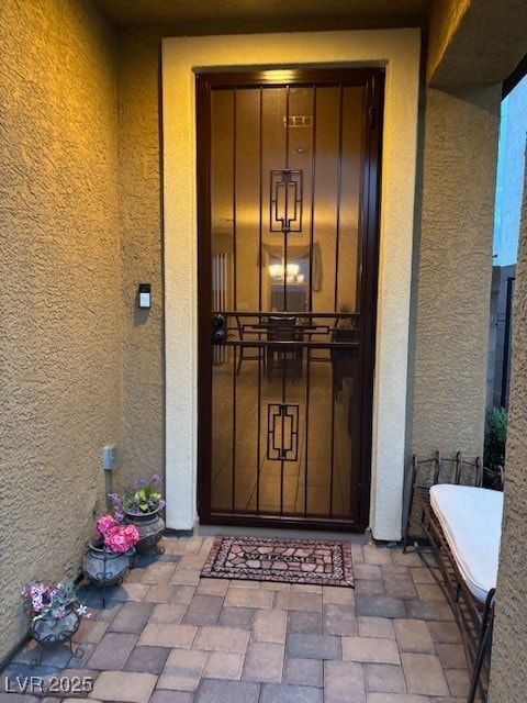 Doorway to property featuring stucco siding
