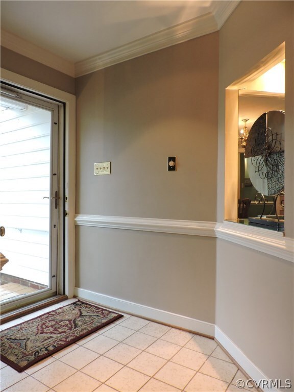 Foyer with beautiful trim work and tile floor.
